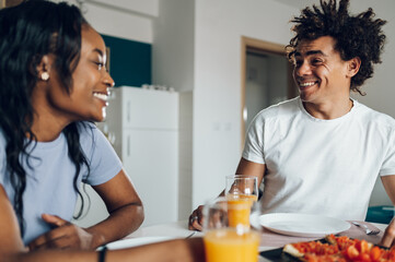 Fototapeta na wymiar African american couple having breakfast in the kitchen at home