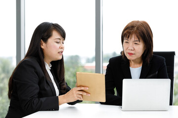 Asian professional successful senior female businesswoman manager in formal suit sitting smiling...