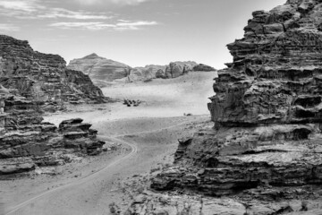 sandy valley, relief mountains, car tracks in the sand, wadi rum desert, Jordan, black and white photo