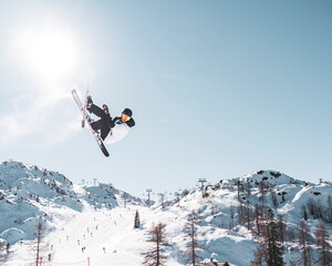 skier doing tricks in the air in snowpark