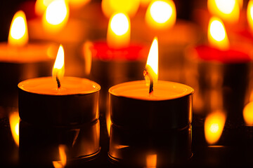 candle,Many candles burn with a shallow depth of field,Burning candles in darkness