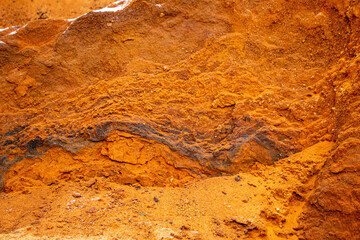 Textural sand, with  relief surface, multi-colored layers and different in size of granules, in outdoor sand career, after mining ore and sand for construction.