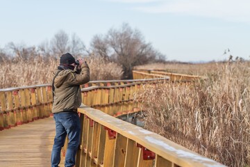 Ornithologist observing nature with binoculars in the Tablas de Daimiel National Park, Ciudad Real (Spain), environmental concept.