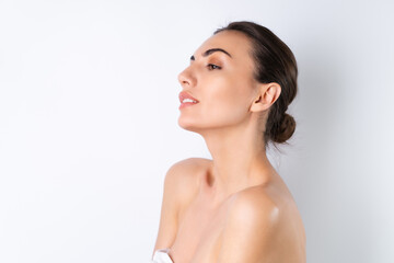 Close beauty portrait of a topless woman with perfect skin and natural make-up, plump nude lips, on a white background.