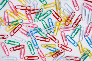Fototapeta na wymiar Cheerful background of colored paper clips on a white background