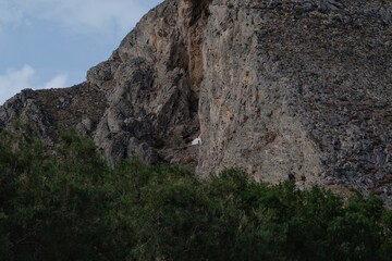 View of a small white chapel build inside a mountain near Perissa in Santorini Greece