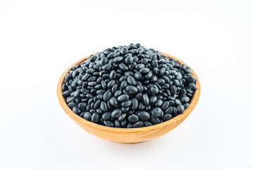 A bowl of small black beans on a white background
