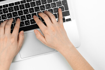 Female hands and laptop keyboard on white office table background. Concept workspace, work at the computer, freelance and design. Flat lay, top view and copy space photo