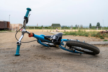 Children's bicycle laid on the ground. On the farm. Blurred background in the background.