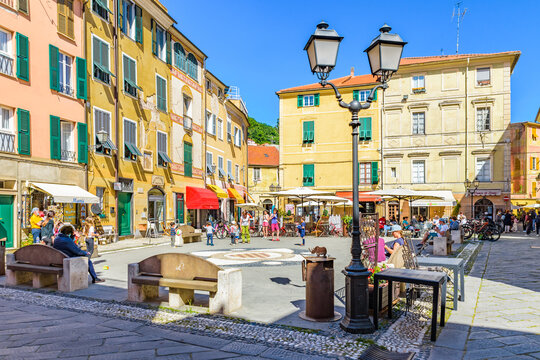Finalborgo, Finale Ligure, Italy. May 5, 2021. View of Piazza Garibaldi with people and tourists sitting outside at the coffee tables.