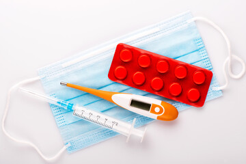 Medical still life on a white background. Syringe, thermometer.