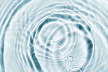 serum or cosmetic liquid drops on water wave surface abstract background. Beauty and skin care concept.