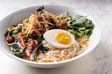 Asian fusion vegan meat-free ramen noodles with mushrooms, fermented tofu, sprout, beans, vegan egg and green pak choi leaves