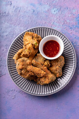 Asian fusion vegan meat-free meal of battered fried broccoli with sweet spicy sauce