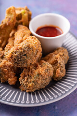 Asian fusion vegan meat-free meal of battered fried broccoli with sweet spicy sauce