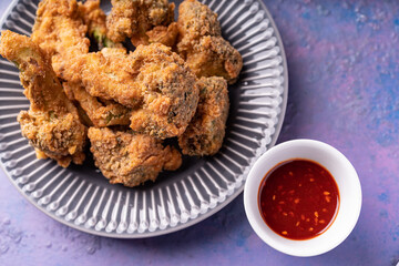 Asian fusion vegan meat-free meal of battered fried broccoli with sweet spicy sauce