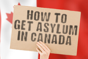 The phrase " How to get Asylum in Canada " on a banner in men's hand with blurred Canadian flag on the background. Claim. Refugee. Immigration. Law. Legislation. Politic. Power. Outlaw. Rule. War