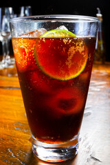 Glass of cola soda with lemon and ice