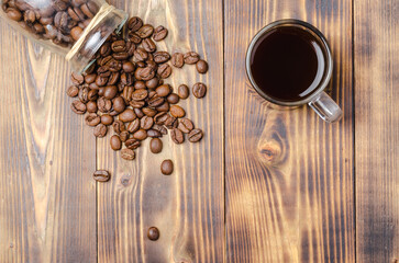 Cup of coffee and beans are scattered from a glass jar.