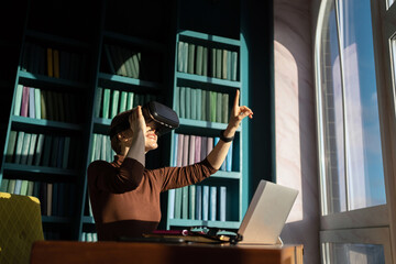 A woman uses virtual reality glasses in a modern office, workplace. VR concept