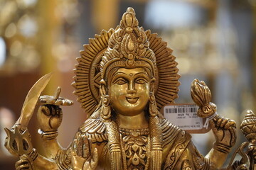Fototapeta na wymiar Bronze statue of Durga goddess sitting on a lion for sale in a shop. Happy Durga Puja. Durgotsava concept. Sculpture of goddess durga. Goddess Durga idol. Religious festival. 