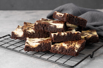 Delicious chocolate brownie cheesecake on a gray concrete background. Copy space, selective focus.