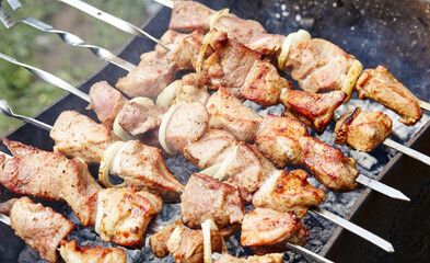 Marinated shashlik preparing on a barbecue grill over charcoal. Traditional Russian shashlik on a barbecue skewer