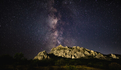 The Milky Way in the starry sky over the Karadag mountain range on a summer night. Delightful landscape. Astrophotography