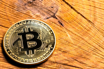 Crypto Coin Bitcoin close-up on a wooden table. Copy space.