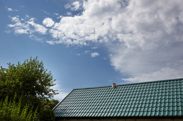 Construction of the roof of the house. Metal tiles against blue sky