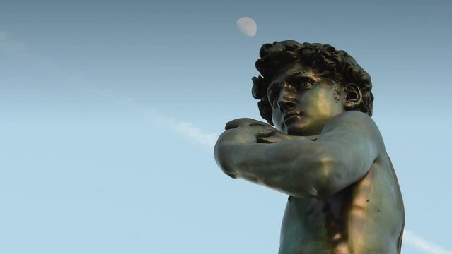 Florence, Michelangelo Square. Detail of the Bronze sculpture of Michelangelo's David facing Florence against blue cloudy sky. Timelapse.