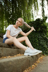 Portrait of an attractive young woman with white hair on the background of the park