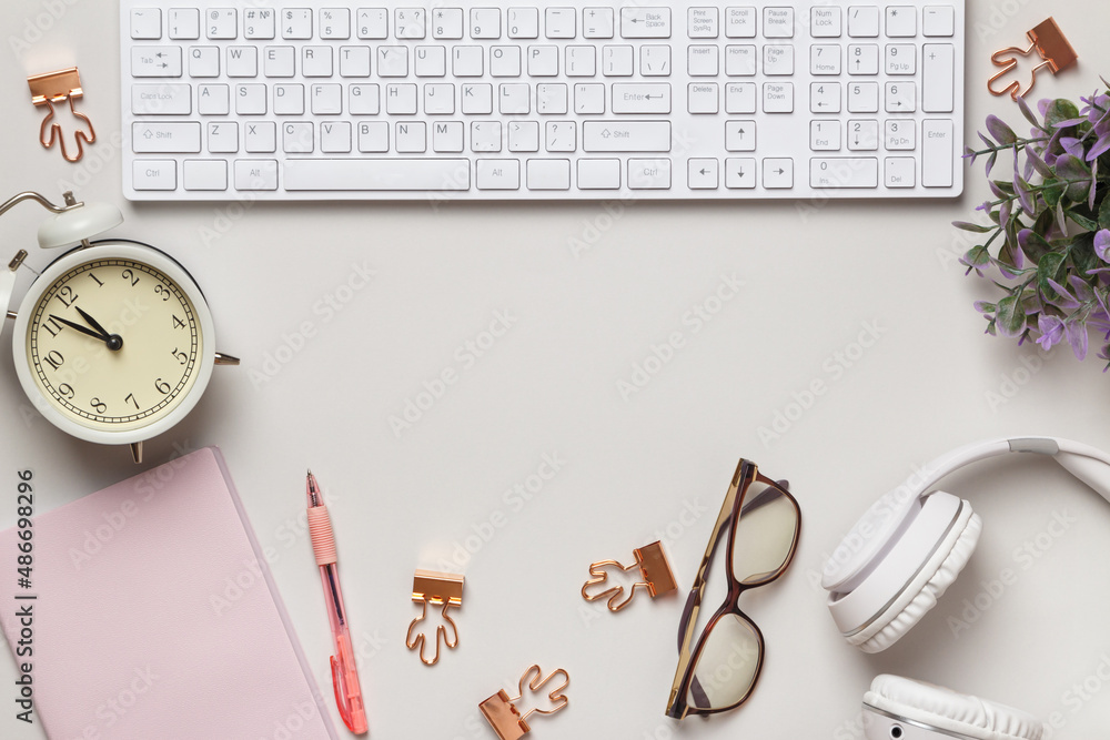 Poster desktop. notepad keyboard alarm clock glasses headphones on the table. frame with copy space