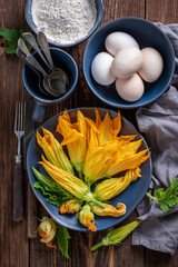 Preparation for fried zucchini flower as unique summer vegetarian snack.
