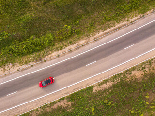 Aerial top down photo. Red car on the highway.