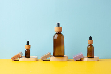 Cosmetic skin care products with soap on blue, yellow background.  Close up, copy space