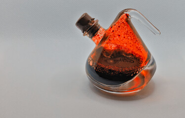 Small bottle of a bloody red ink on a light background