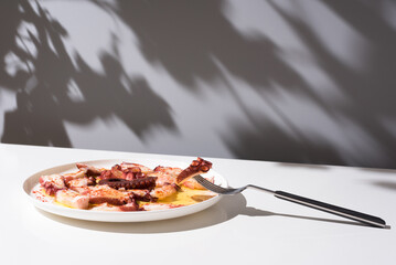 Plato de pulpo a la gallega con pimentón y aceite de oliva. Tapa típica española sobre mesa blanca y fondo gris	 - obrazy, fototapety, plakaty