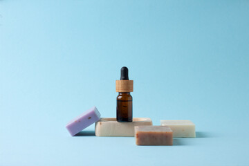 Cosmetic bottle with soap on blue background.  Close up, copy space