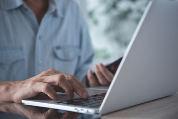Business man working on laptop computer at home office, telework, telecommuting, work from home concept