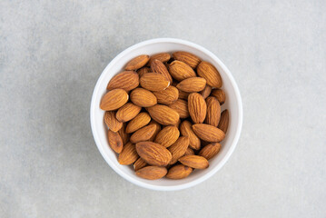 almonds in a white cup on a concrete background. concept for a recipe for making almond flour. top view