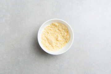 freshly ground almond flour in a white bowl on a concrete background. concept for a recipe for making almond flour. top view