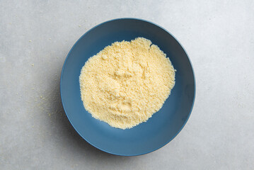 freshly ground almond flour in a blue bowl on a concrete background. concept for a recipe for making almond flour. top view