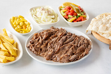 Doner kebab on a white background. Traditional Turkish cuisine flavor meat doner. With lavash bread, french fries, salad and onions on the side
