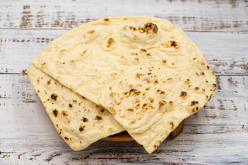 Homemade bread (pita, puri, chapati, lavash bread) on wooden background.