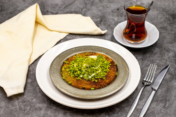 Pistachio kunefe on dark background. Traditional Turkish cuisine flavor