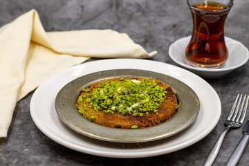 Pistachio kunefe on dark background. Traditional Turkish cuisine flavor