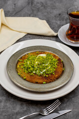 Pistachio kunefe on dark background. Traditional Turkish cuisine flavor