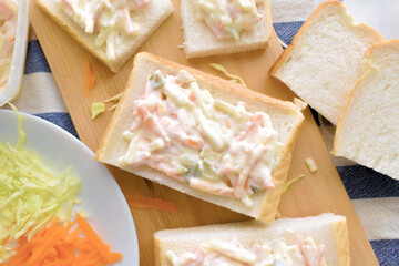 Creamy coleslaw sandwich on a bamboo cutting board.  Food from above concept.  Flat lay top view food photography.