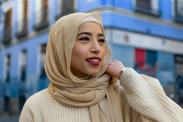 Beautiful Arabic muslim woman wearing yellow hijab, stylish female face portrait over city street